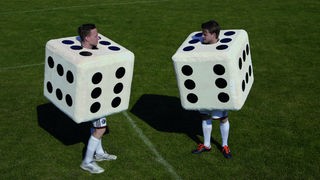 Zwei Fußballspieler mit Würfel-Kostüm.