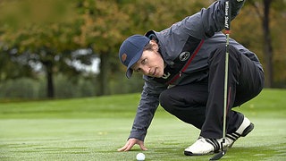 Johannes hockt vor dem Ball auf dem Rasen.