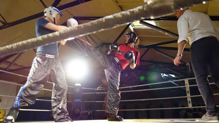 Johannes und Gegnerin bei Boxkampf in Ring.
