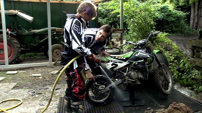 Timo und Johannes putzen ein Motorrad.