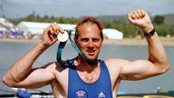 Ruder-Chamion Sir Steven Redgrave hält mit beiden Armen jubelnd seine olympische Goldmedaille / Sydney 2000 in die Höhe.