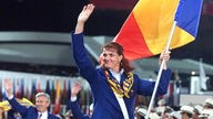 Elisabeta Lipa trägt bei der Eröffnungsfeier zu den olympischen Sommerspielen in Sydney die rumänische Fahne beim Einzug der Mannschaft Rumäniens in das Olympiastadion und winkt.
