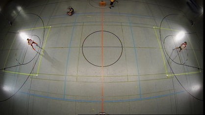Spielfeld und Spieler in Halle, von oben fotografiert.