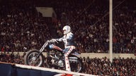 Stunt-Legende Evil Knievel auf Motorrad vor Publikum.