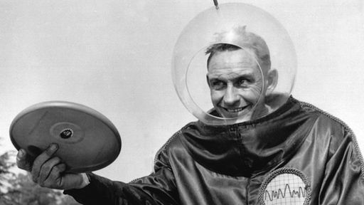 Walter Frederick Morrison mit Frisbee und Astronauten-Anzug.