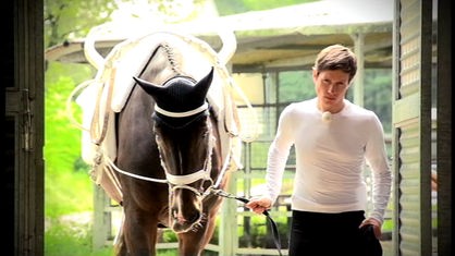 Johannes führt ein Pferd in den Stall.