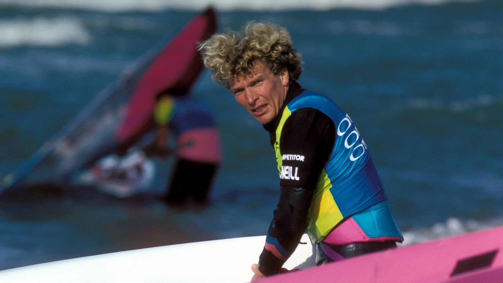 Jürgen Hönscheid steht mit Board im Wasser.