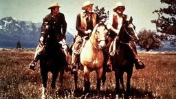 Aufnahme aus dem Western Bonanza mit Little Joe, Pa Ben und Eric Cartwright auf Westernpferden sitzend. 
