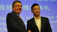 Lu Chunlong schüttelt die Hand von Thomas Bach, dem Präsidenten des Internationalen Olympischen Kommittees.