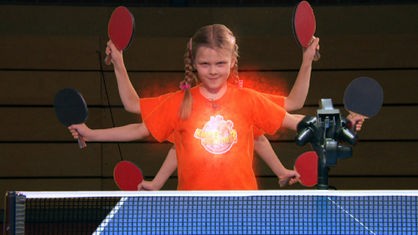 Mädchen steht an Tischtennisplatte und scheint sechs Arme zu haben.