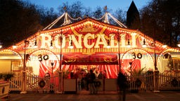 Beleuchtetes Zelt des Zirkus Roncalli in Dämmerung.