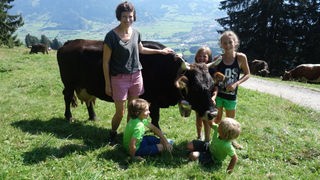 Malin mit Kindern vor einer Kuh