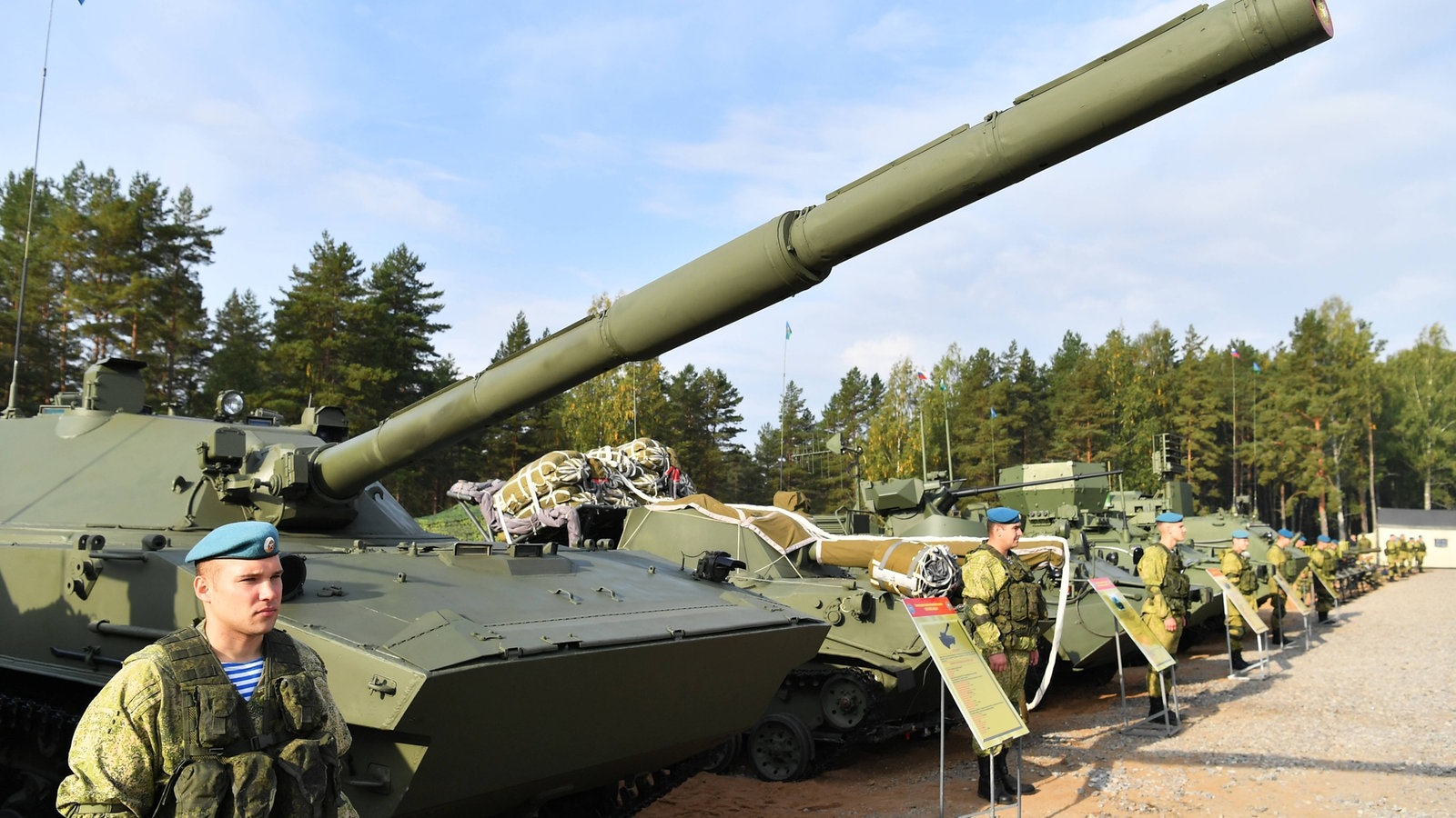 Russischer Soldat steht neben Militärfahrzeugen.