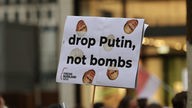 Schild mit der Aufschrift "drop Putin, not bombs".