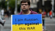 Demonstrant in Sydney mit blau-gelbem Plakat mit der Aufschrift "I am Russian. I am against this war". 