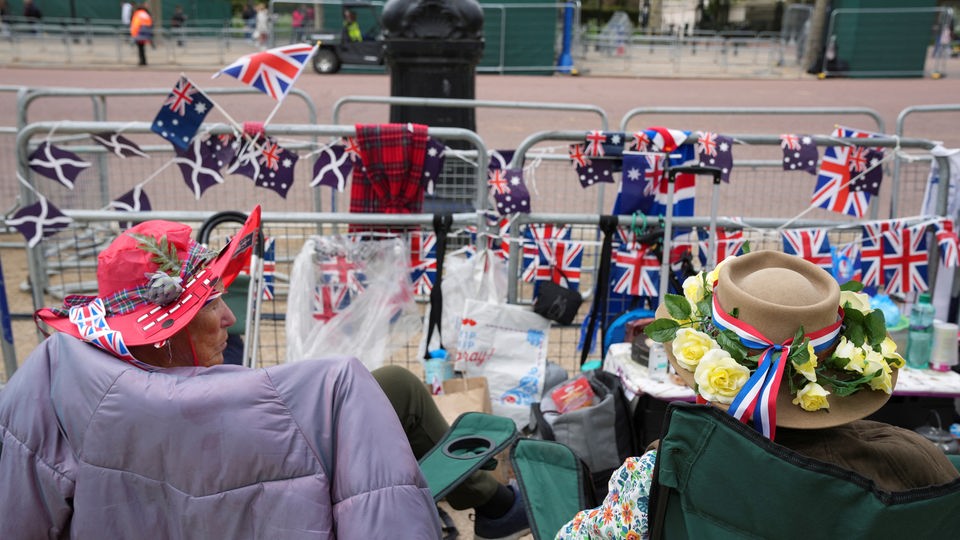 Royal-Fans warten vor dem Buckingham Palace auf die Krönungszeremonie. 