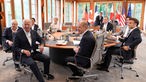 Die G7-Staats- und Regierungschefs sitzen mit Ursula von der Leyen an einem Verhandlungstisch.