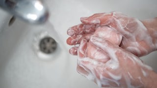 Ein Kind wäscht sich die Hände.