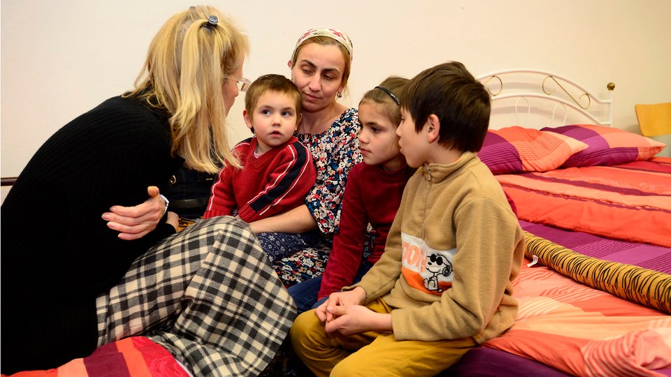 Familie mit vier Kindern sitzt auf Etagenbett