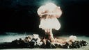 Ein Atompilz steigt nach der Explosion einer Atombombe über dem Testgelände in der Wüste von Nevada auf