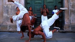 Zwei Männer tanzen Capoeira.