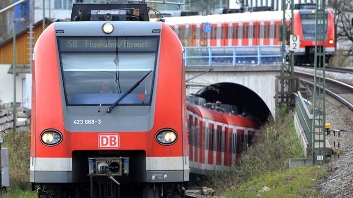 Ein roter Zug der Deutschen Bahn fährt in einen Tunnel.