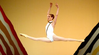 Eine Ballettänzerin vollführt den Sprung "Grand jeté".