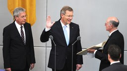 Bundespräsident Christian Wulff legt mit erhobener Hand seinen Amtseid ab.