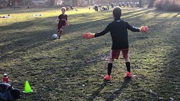Zwei Jungen spielen Fußball im Park.
