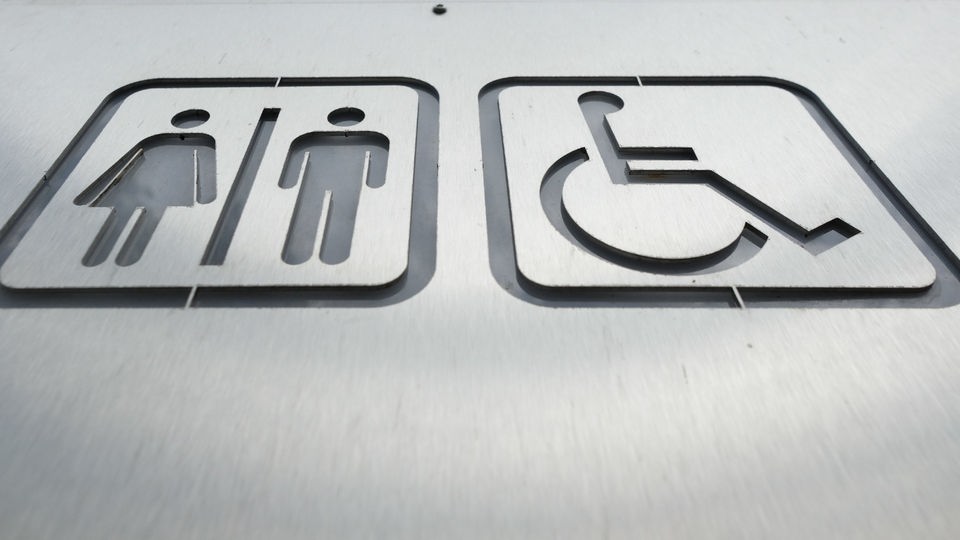 Schild mit Piktogramm zu öffentlichen Toiletten inklusive Behindertentoilette.