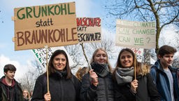 Schülerinnen bei einer Demonstration der Bewegung "Fridays for Future" mit einem Plakat mit der Aufschrift "Grünkohl statt Braunkohle".