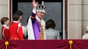 König Charles III. winkt nach der Krönungszeremonie vom Balkon des Buckingham Palastes aus der Menge zu.