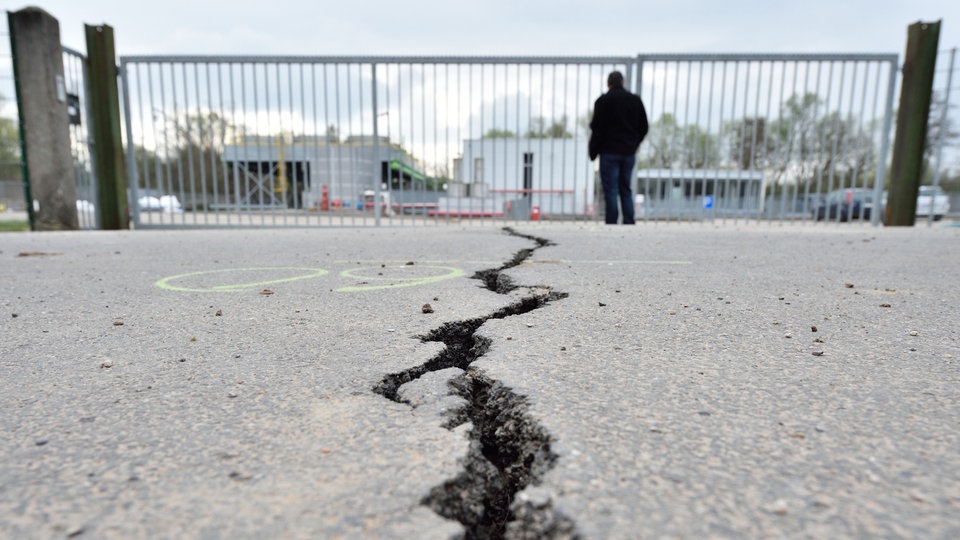 Ein Riss im Asphalt einer Straße in Landau vor der Einfahrt zum Geothermiekraftwerk.