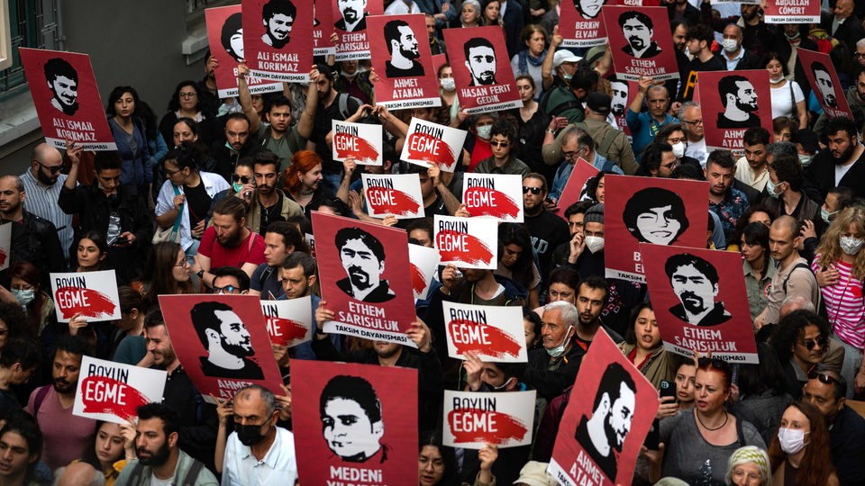 Demonstranten protestieren gegen die Verurteilung des Menschenrechtlers Osman Kavala und halten Schilder hoch.