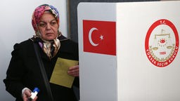 Eine Türkin an der Wahlkabine.