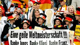 Fans der deutschen Nationalmannschaft in schwarz-rot-goldener Kleidung.