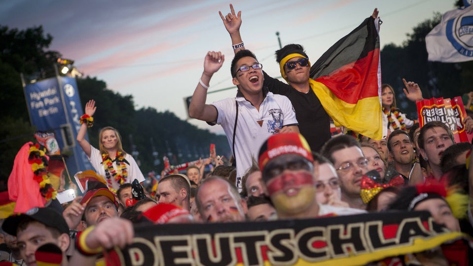 Fans der deutschen Mannschaft jubeln auf der Fanmeile vor dem Brandenburger Tor in Berlin beim Public Viewing zur EM 2012.