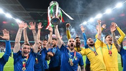 Die italienische Nationalmannschaft hält nach ihrem Sieg 2021 den Pokal in die Höhe.