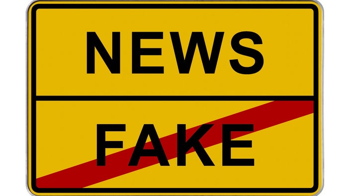 Gelbes Verkehrsschild mit der Aufschrift "News/ Fake (durchgestrichen)".