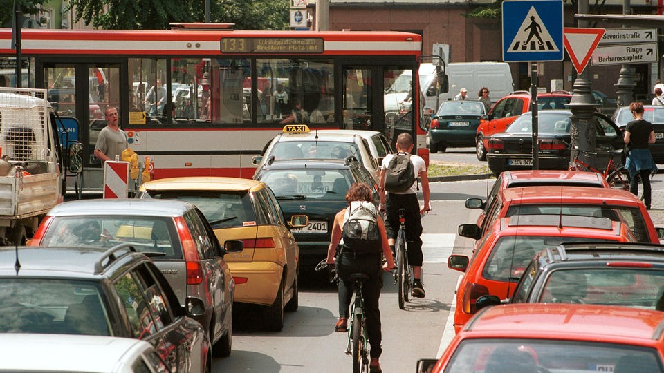 Innerstädischer Straßenverkehr mit Bussen Autos, Radfahrern und Fußgängern am einem Kreisverkehr am Chlodwigplatz in Köln