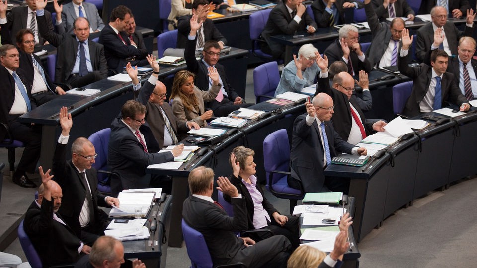 Die Abgeordneten der Grünen- Fraktion heben im Bundestag bei einer Abstimmung die Hände.