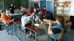 Eine Gruppe Schüler wirft im Klassenraum mit Gegenständen um sich