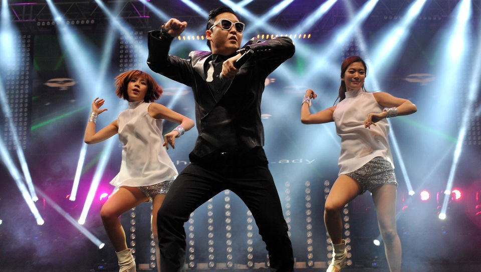 Der südkoreanische Rapper Psy tanzt mit Mikrofon in der Hand.