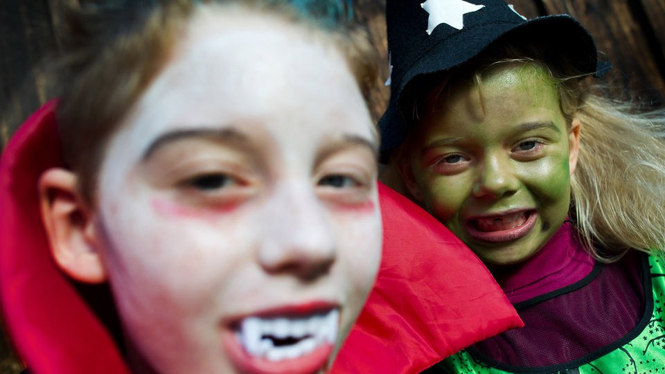 Ein Junge und ein Mädchen haben sich als Vampir und Hexe verkleidet.