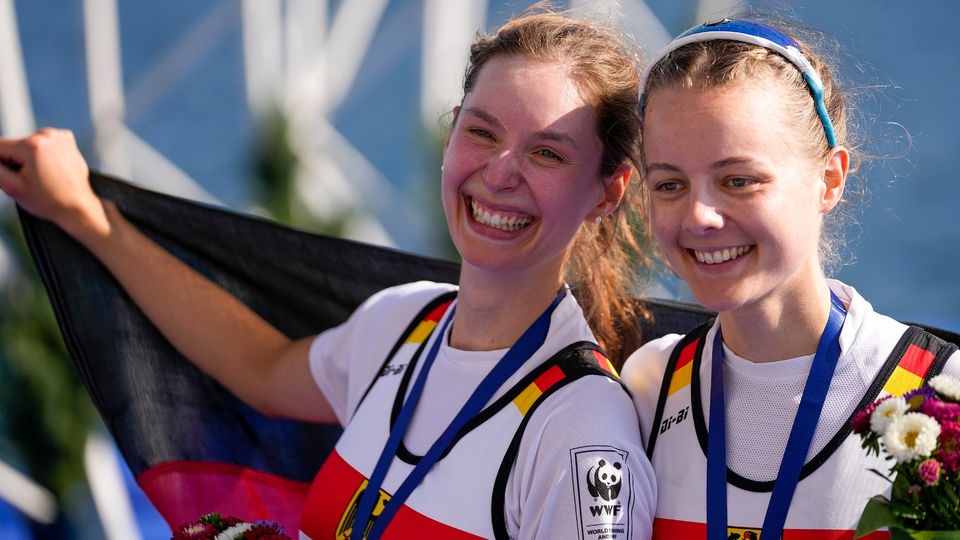 Die Ruderinnen Luise Münch und Eva Hohoff lachend mit Medaillen.