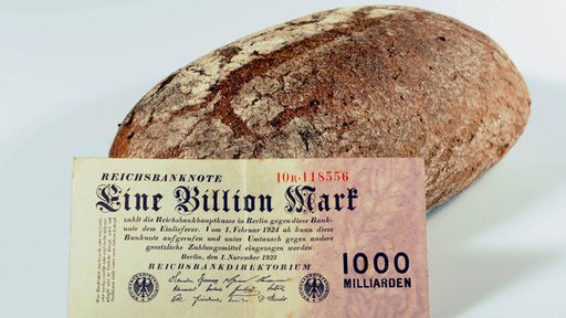 Geldschein im Wert von einer Billion Reichsmark vor einem Brotlaib. 