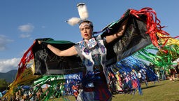 Eine Frau in traditioneller indianischer Tracht tanzt auf einem Powwow in Vancouver.