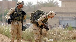 Bewaffnete amerikanische Soldaten patrouillieren im Irak.