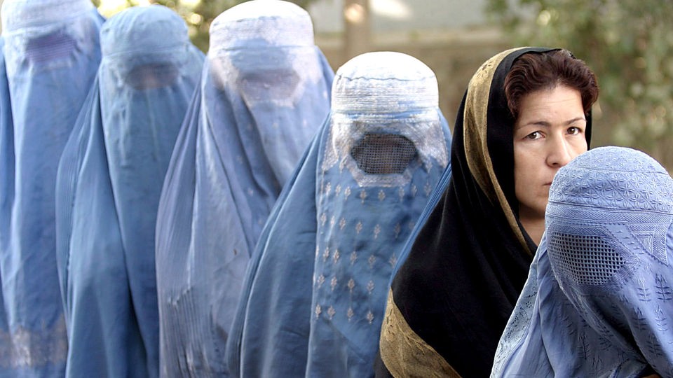Vier irakische Frauen im traditionellen Schador, dazwischen eine mit Kopftuch.