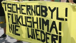Gelbes Transparent bei Demonstration, Aufschrift: Tschernobyl! Fukushima! Nie Wieder